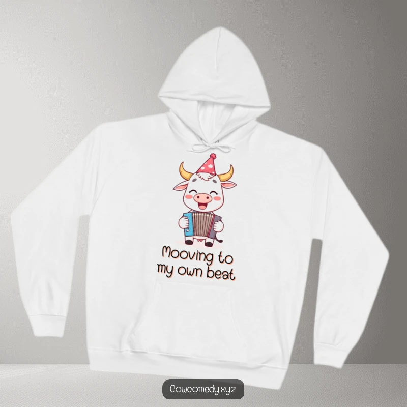 Funny hoodie with a cheerful cow in a party hat playing a tiny accordion, radiating fun and musical joy.